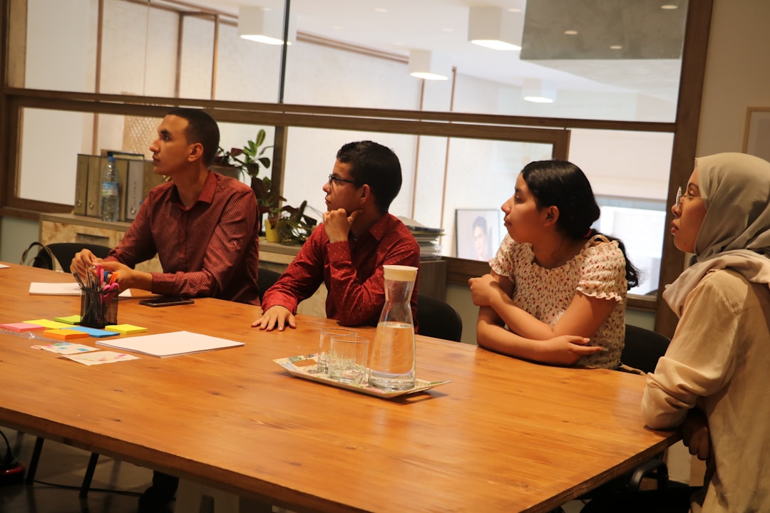 Multi-generational team members in genuine discussion around conference table