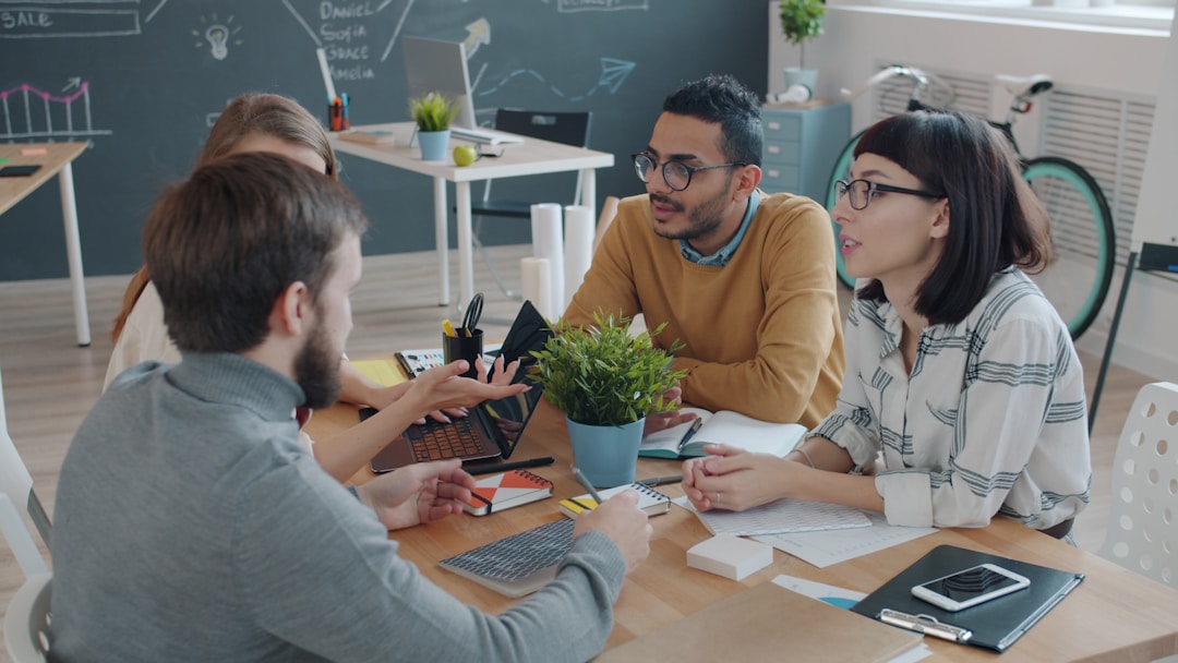 Management team in focused discussion around conference table examining business metrics