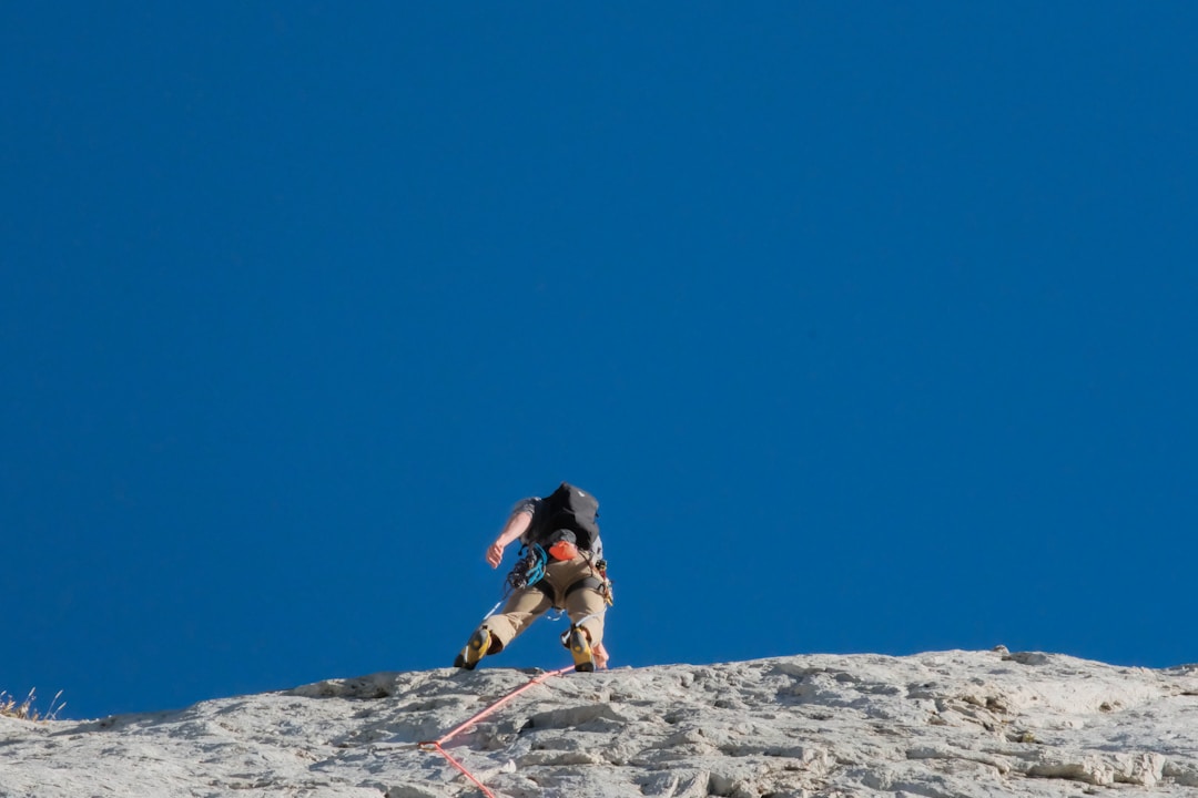 Silhouette of climber reaching mountain peak representing successful navigation of compliance challenges