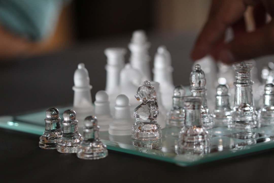 Fallen chess king piece surrounded by standing pieces symbolizing leadership vulnerability