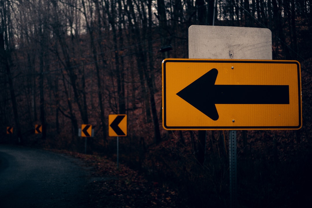 Rock climber at mountain trail junction deciding between multiple paths forward
