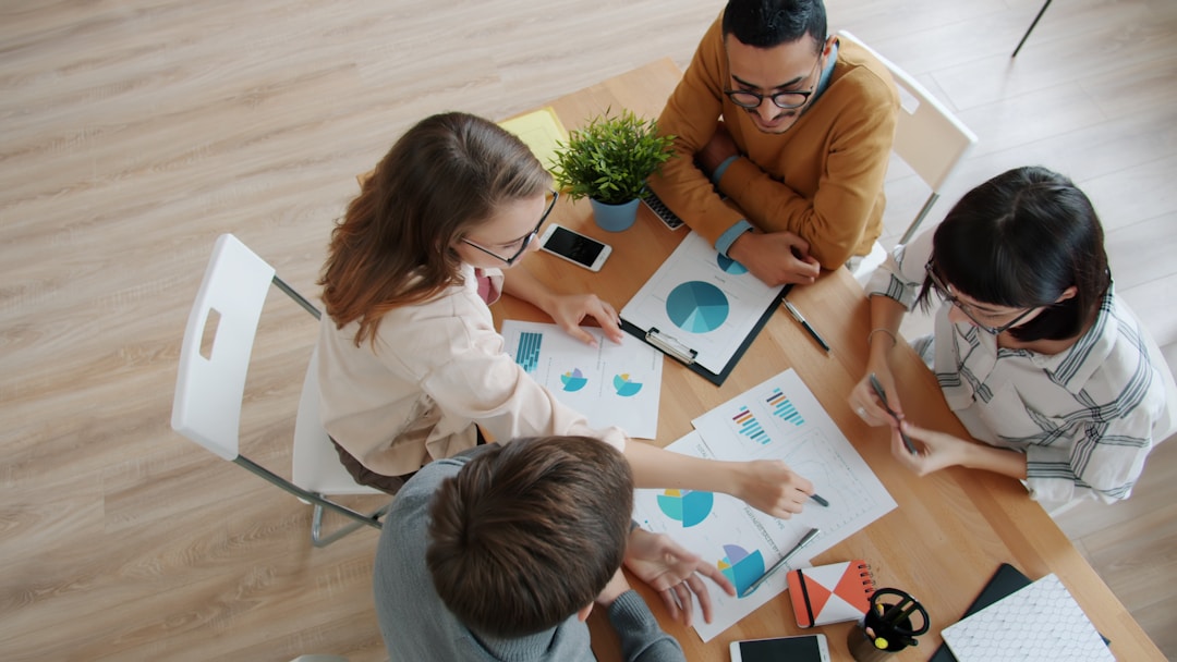 Multi-person team engaged in strategic discussion around conference table with documents