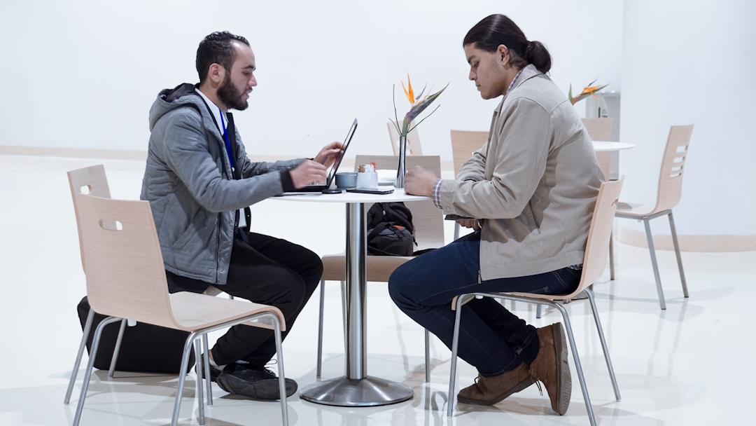 Two professionals in discussion examining financial documents, showing real engagement and skepticism